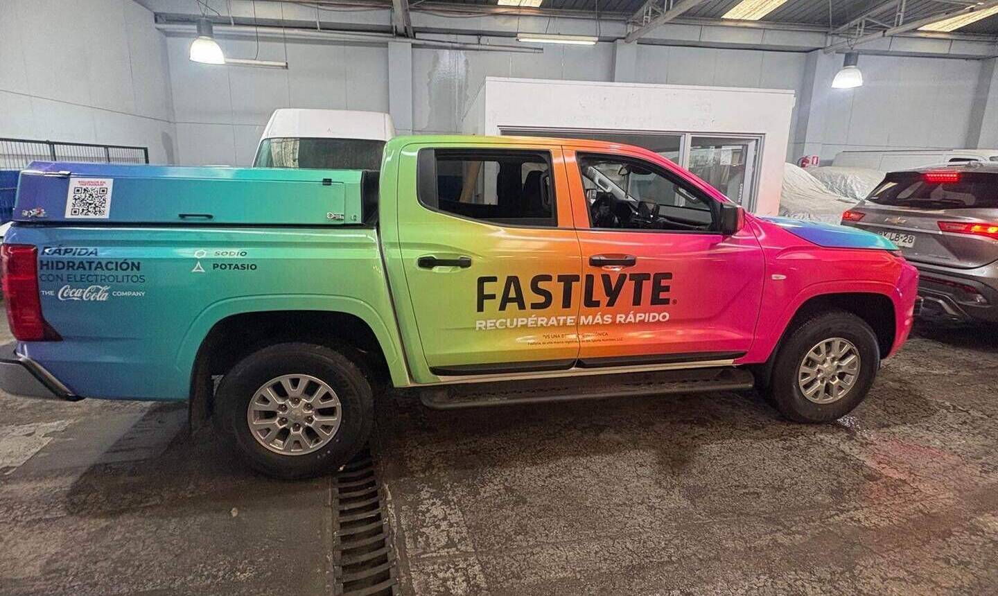Camioneta L200 FASTLYTE de The Coca-Cola Company con rotulación completa multicolor