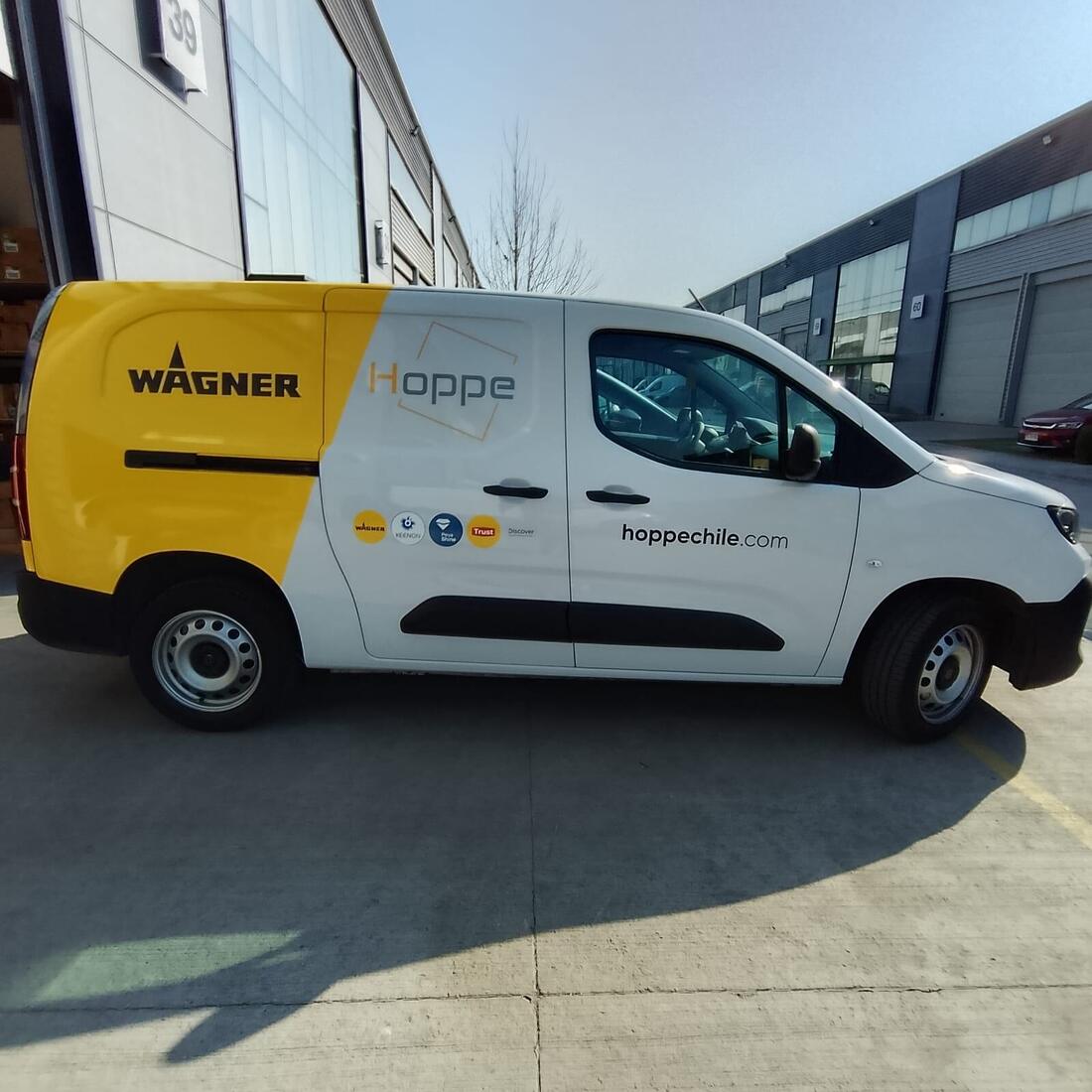 Van de reparto amarilla y blanca con rotulación corporativa bicolor y datos de contacto en la puerta